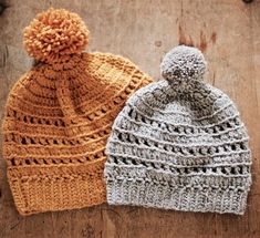 two knitted hats sitting on top of a wooden table