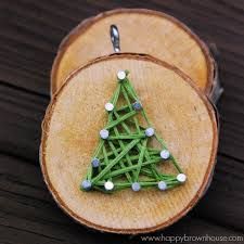 a christmas tree ornament made out of green string on a piece of wood