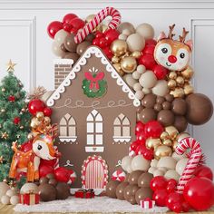 a gingerbread house is surrounded by balloons and christmas decorations