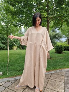 Experience unmatched comfort and stylish design with the Linen Kimono Oversized Dress - Morkva Dune. Crafted from 100% organic linen, this dress is perfect for any body type, thanks to its uniquely wide cut. The design of this dress is inspired by traditional Japanese kimonos and the iconic characters from the film "Dune", traveling across vast deserts. This combination gives the dress a distinctive character, making it a true masterpiece in the world of fashion. The Morkva Dune Kimono Dress will not only amaze everyone with its extraordinary appearance but also provide you with incredible comfort. The natural linen and loose fit create a lightweight, breathable garment, ideal for warm weather. Discover the perfect blend of style and comfort with the Morkva Dune Dress and become the center Spring Linen V-neck Kaftan, Oversized Linen Maxi Dress, Oversized Linen V-neck Dress, Oversized Linen Kaftan For Spring, Oversized Linen V-neck Maxi Dress, Oversized Linen Maxi Dress With V-neck, Oversized Beige Linen Dress, Beige Loose Fit Linen Beach Dress, Oversized Beige Linen Beach Dress