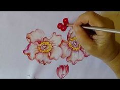 someone is drawing flowers with watercolors on paper and using a pencil to draw them