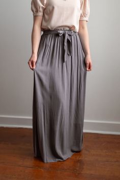 Breathing timeless charm, the Kristin pull-on style skirt features a comfortable elastic waistband with an attached tie belt at the waist front. It falls to the ankle in graceful gathers. Complete the feminine look with an elegant blouse. Fit: true to size Style: gathered dress skirt with elastic waistband and attached tie at the waist Color: charcoal Fabric content: 100% rayon Care instructions: wash gentle cycle, cold; lay flat to dry, cool iron if needed. For best results, always follow care instructions on garment label. Our sizing is always approximate and can vary due to personal preference and style. For the best experience - and to make life easier for everyone! - please carefully measure yourself before placing your order and allow 1" variance due to product manufacturing. If you Flowy Maxi Skirt With Elastic Waistband For Day Out, Elegant Bottoms With Gathered Waist For Daywear, Stretch Maxi Skirt With Elastic Waistband For Daywear, Versatile Solid Color Maxi Skirt With Elastic Waistband, Solid Color Flowy Skirt With Banded Waist, Versatile Solid Skirt With Elastic Waistband, Versatile Solid Color Skirt With Elastic Waistband, Modest Solid Skirt With Elastic Waistband, Modest Bottoms With Elastic Waistband For Day Out