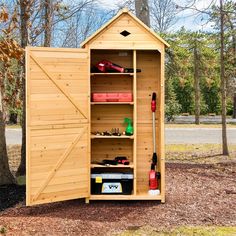 a wooden shed with its doors open and tools in the storage compartment on the outside