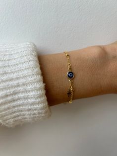 Brush away negative energy and stay protected with this dainty evil eye bracelet! D E T A I L S *It features a gold filled evil eye charm (12 x 6.5mm) in traditional blue *on a high quality 18k gold filled chain in yellow gold. *Gold filled is a wonderful alternative to solid gold and unlike gold plating does not rub off. *A tiny gold filled cross dangles from the chain. *It closes with a hall marked gold filled spring clasp measuring 6mm. *Choose the length from the drop down menu. Use the length guide as a reference to help you get the right size. Bracelet needs to be snug to stop it rolling. C A R E * T I P :  To keep your bracelet in great condition avoid contact with water, perfume and chemicals. Also remove when exercising and sleeping . P A C K A G I N G: All our products are gift r Everyday Yellow Gold Evil Eye Bracelets, Gold Spiritual Evil Eye Bracelet For Everyday, Gold Spiritual Evil Eye Bracelet With Adjustable Chain, Dainty Adjustable Gold Evil Eye Bracelet, Dainty Gold Adjustable Evil Eye Bracelet, Dainty Gold Evil Eye Bracelet, Adjustable, Dainty Gold Evil Eye Bracelet, Evil Eye Bracelet For Everyday Wear, Gold Dainty Evil Eye Bracelet With Adjustable Chain