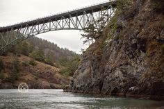 a large bridge over a river next to a cliff