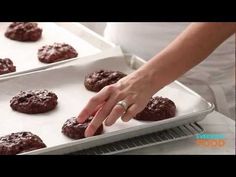 a person placing cookies on top of a cookie sheet