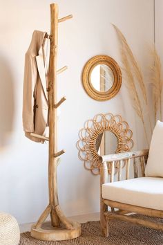 a wooden coat rack next to a chair and mirror