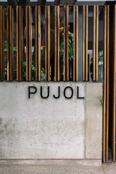 the entrance to pujol is made out of concrete and wood slatted