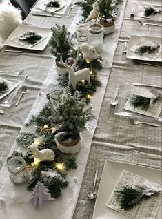 the table is set for christmas dinner with silverware and white napkins on it