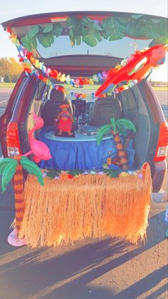 the back end of a car with decorations on it and a table in the trunk