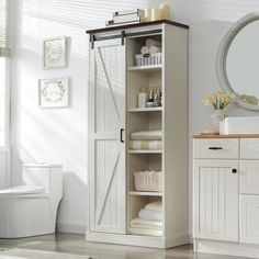 a bathroom with a white toilet and wooden cabinet