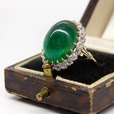 The Melinda ring is an authentic vintage design. This ring centers one natural cabochon cut emerald that weighs 18ctw approx. and is surrounded by 22 old mine cut diamonds of I color, VS2 clarity that weigh 1.30ctw. The stones are set in a platinum setting with details in 18k gold. Luxury Platinum Cabochon Jewelry, Luxury Fine Jewelry Gemstone Ring, Luxury Elegant Ring With Natural Stones, Luxury Emerald Rings For Jewelry Making, Luxury Vintage Emerald Ring With 17 Jewels, Luxury Vintage Emerald Ring, Luxury Untreated Antique Rings, Luxury Antique Ruby Ring With Center Stone, Luxury Antique Ring With Antique Finish