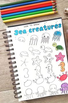 an open notebook with sea creatures drawn on it and colored pencils next to it