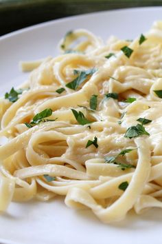 a white plate topped with pasta and parsley