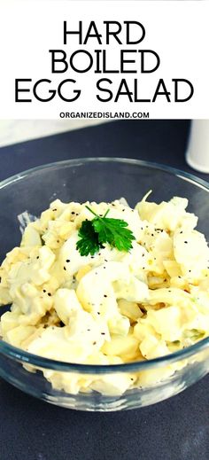 an egg salad in a glass bowl with parsley on top and the words, hard boiled egg salad