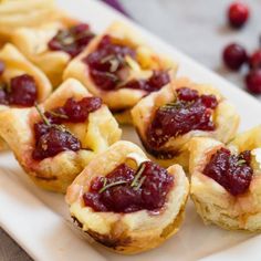 small pastries with cranberry sauce on a white plate