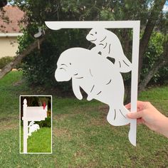 a hand holding up a cutout of a dog riding a horse in the yard