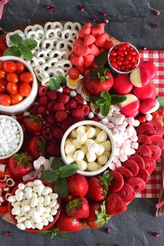 a platter filled with fruits and vegetables on top of a checkered table cloth