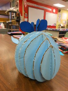 an ornament made to look like a blue hat on a table in a classroom