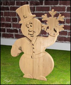 a wooden snowman standing in front of a brick wall