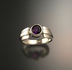 Amethyst natural 6mm round stone is deepest color. Well cut and eye-clean natural stone from Nigeria weighs a little over 1ct. Bezel set with forged tapered multidimensional band. Specify your size at check-out. Modern Amethyst Ring With Bezel Setting, Modern Round Birthstone Ring With Tension Setting, Modern Amethyst Ring With Polished Finish, Modern Amethyst Rings In Round Shape, Modern Amethyst Round Rings, Modern Amethyst Rings, Modern Amethyst Birthstone Ring, Modern Round Amethyst Ring, Modern Sterling Silver Round Amethyst Ring