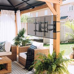 a covered patio with wicker furniture and plants