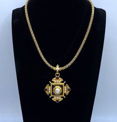 "This is a rare Monet necklace by Christian Lacroix. This Monet pendant necklace is a vintage Monet Maltese pendant and necklace that is featured in the \"Monet the Master Jewelers\" book by Alice Vega on page 283. This pendant was under license from Christian Lacroix in 1995. The pendant has pearl cabochons, dark red cabochons and black enamel on a matte gold tone. The piece is not signed Christian Lacroix, the licensed series were signed by Monet. The gold tone chain necklace is in mint condition but notice the dip in enameling on the pendant shown in the last photo. The velvet gift box is included in the purchase. Rare Monet Necklace By Christian Lacroix Monet Pendant Necklace Signed Monet, Monet Jewelry, Vintage Monet Pendant Please see the photos and don't hesitate to contact me to as Antique Cross Pendant Necklace For Formal Occasions, Vintage Large Cross Pendant Jewelry, Vintage Cross Necklace Collectible, Vintage Medallion Pearl Pendant Necklace, Collectible Gold Necklaces With Cross Pendant, Collectible Gold Cross Pendant Necklaces, Elegant Collectible Cross Necklaces, Elegant Cross Necklace For Collectors, Antique Cross Necklace With Large Pendant