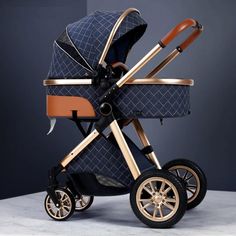 the baby stroller has two wheels and is blue with gold trims on it