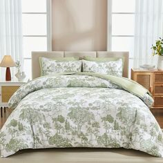 the comforter is green and white with trees on it