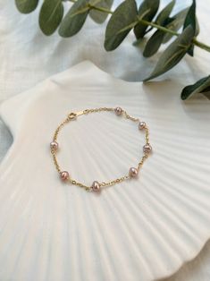 PRODUCT DETAILS Cable chain in 14K Gold Filled  Closure and components in 14K Gold Filled Natural Pink Freshwater Pearls (approx. 4-5 mm)  BRACELET MEASUREMENTS Available sizes are S (16 cm), M (17 cm) and L (18 cm). WHAT IS GOLD FILLED?  * Gold filled is created by mechanically bonding a layer of gold to a layer of base metal and is the perfect choice if you're looking for a material that is higher quality than gold plated, but an affordable alternative to solid gold.  * Gold Filled jewelry can last a lifetime if taken care of properly and is both hypoallergenic and anti tarnish resistant.  WHAT IS VERMEIL? * Vermeil is a thick layer of real gold (at least 10k) over a base layer of Sterling Silver. It's a type of gold jewelry made to last and because of the thick layer of gold it is less Pink Pearl Bracelet With Pearl Drop, Elegant Pink Bracelets With Pearl Chain, Pink Dainty Pearl Bracelet, Pink Pearl Chain Bracelet As Gift, Dainty Pink Pearl Bracelets, Delicate Pink Round Bracelets, Delicate Pink Pearl Beaded Bracelet, Dainty Pink Pearl Bracelet With Pearl Charm, Dainty Pink Pearl Bracelet