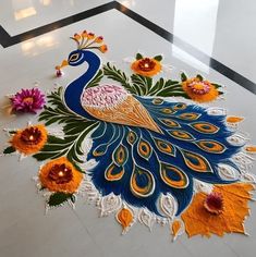 a peacock is on the floor with flowers and candles in it's centerpiece