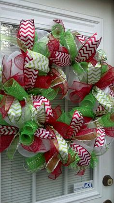 a green and red wreath on the front door