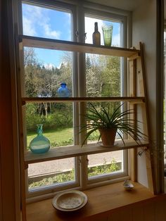 there is a vase on the window sill next to a plate and glassware