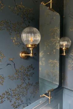 a bathroom with two mirrors and lights on the wall