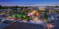 an artist's rendering of the town square at dusk, with cars and people walking around