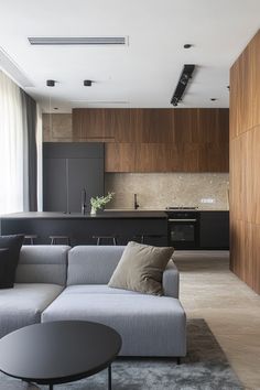 a living room filled with furniture next to a kitchen