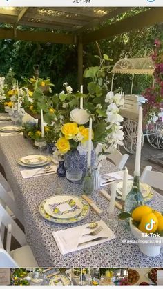 the table is set with blue and white plates, vases filled with yellow flowers