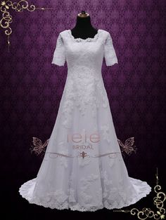 a white wedding dress with short sleeves on a mannequin stand in front of a purple wall