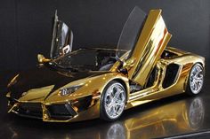 a gold colored sports car with its doors open