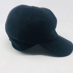 a black hat is sitting on a white surface