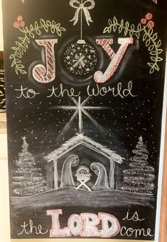 a chalk board with the words joy to the world and an image of a nativity scene