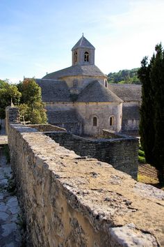 an old stone building with a clock tower in the middle of it's roof