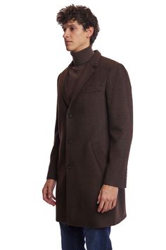 The Chocolate Brown Notch Topcoat is a timeless addition to any wardrobe. Crafted from a poly-wool blend, it features a classic notch collar, faux hair texture, and front pockets for practicality. Its rich chocolate hue and tailored fit make it appropriate for both formal and casual settings. This ensures you stay warm and stylish throughout the colder months.PRODUCT DETAILS: style 6491C slim-fitting long sleeve notch collar faux hair texture poly-wool blend dry clean only imported Brown Business Outerwear With Concealed Placket, Business Brown Wool Coat With Concealed Placket, Classic Brown Wool Coat For Business, Tailored Brown Wool Coat With Concealed Placket, Classic Brown Wool Coat With Button Closure, Brown Pea Coat With Lapel Collar And Concealed Placket, Brown Wool Coat With Hidden Button Closure For Business, Classic Single-breasted Brown Wool Coat, Classic Tailored Brown Wool Coat