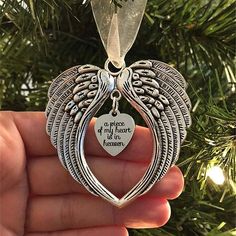 an angel ornament hanging from a tree with the words, a price of my heart is heaven