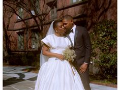 a bride and groom standing in front of a building