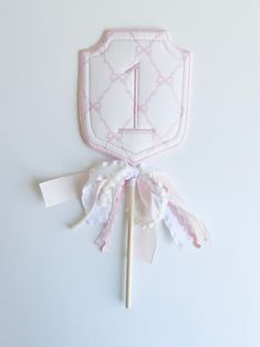 a pink and white cake topper with the number one on it's side