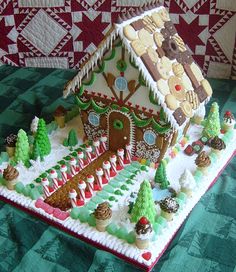 a large gingerbread house with trees and cookies on it's roof is shown