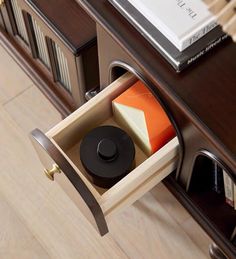 an open drawer on the side of a desk with books and other items in it