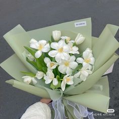 a person holding a bouquet of white flowers