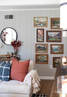 a living room filled with furniture and pictures on the wall